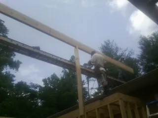 Carpenter setting a ridge beam over a new addition frame — Ice Dam Removal by Roofing Brothers in Ashfield