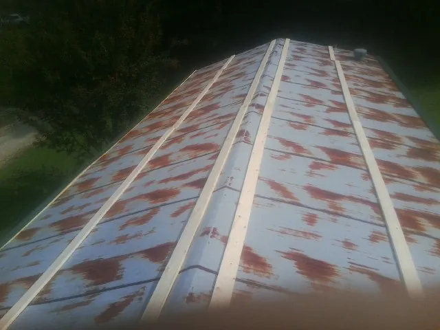 Rusted metal roof panels with new wood purlins before replacement — Storm Damage Roof Repair in Ashfield by Roofing Brothers